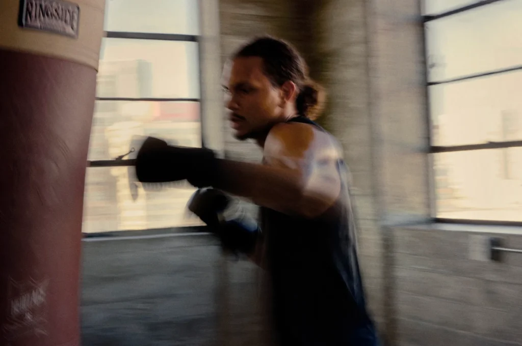 Person punching a heavy bag in gym.