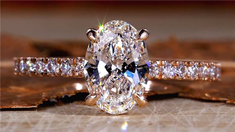 Oval diamond ring on textured surface.